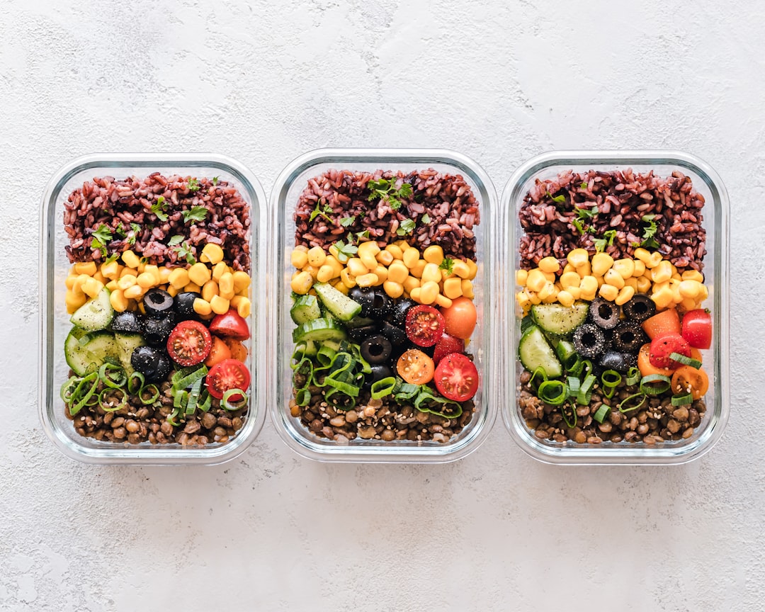 A clean kitchen countertop with meal prep containers filled with colorful vegetables and grains, ready for the week ahead.